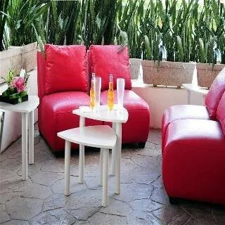 Sodoben kotiček za sprostitev z rdečimi naslanjači na terasi hotela Ambiance Suites.
