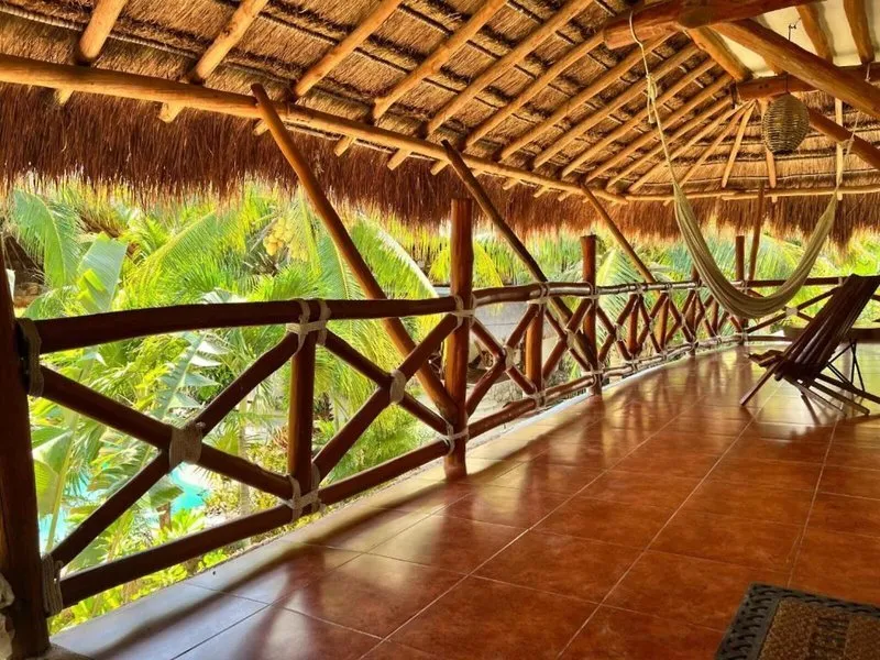 Prostoren balkon s hamako in pogledom na tropsko zelenje