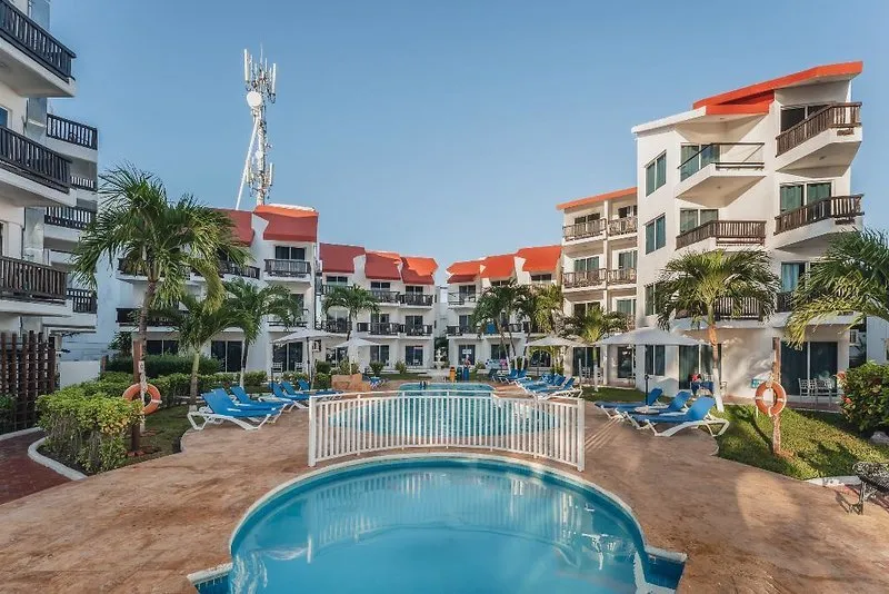 Zunanji bazenski kompleks z ležalniki in palmami