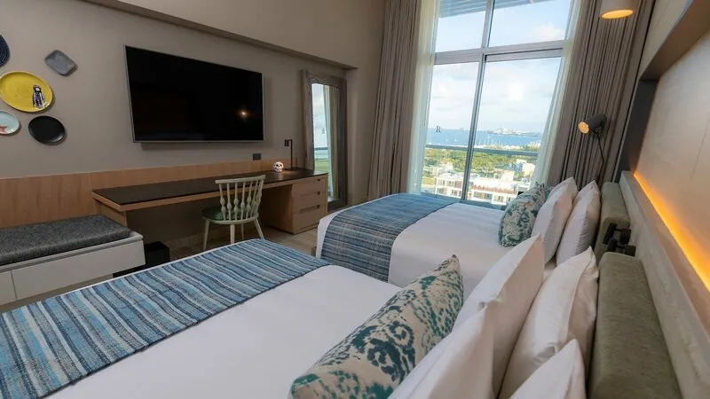 Sodobna hotelska soba z velikim TV zaslonom in pogledom na marino