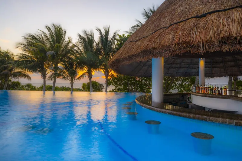 Infinity bazen s slamnato streho bara ob sončnem zahodu