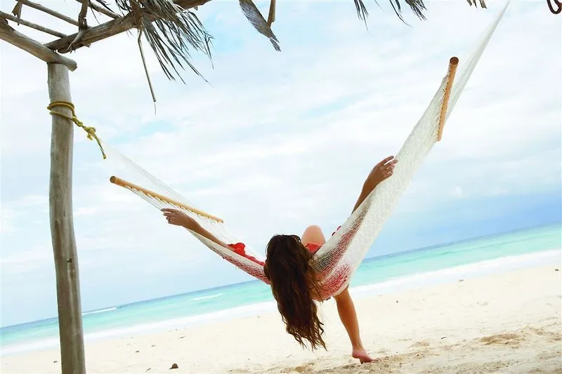 Sprostitev v viseči mreži na beli peščeni plaži Cancuna.